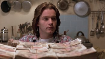 Movie still from “Shallow Grave” (1994), directed by Danny Boyle – A man sitting in front of a pile of money; Close Up shot, Over the shoulder angle