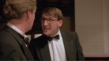 Movie still from “Shallow Grave” (1994), directed by Danny Boyle – A man in a suit talks to another man in a suit; Close Up shot, Over the shoulder angle