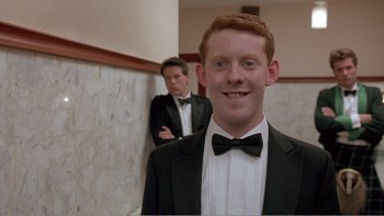 Movie still from “Shallow Grave” (1994), directed by Danny Boyle – A man in a tuxedo standing next to another man in a suit; Medium shot, Low angle