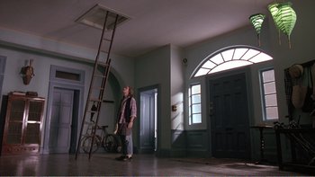 Movie still from “Shallow Grave” (1994), directed by Danny Boyle – A man standing next to a ladder in a room; Wide shot, Low angle