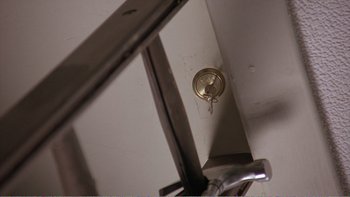 Movie still from “Shallow Grave” (1994), directed by Danny Boyle – A clock in the corner of a room; Extreme Close Up shot, Overhead angle