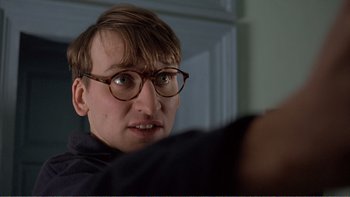 Movie still from “Shallow Grave” (1994), directed by Danny Boyle – A man with glasses looking at the camera; Close Up shot, Low angle