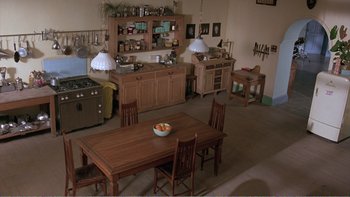 Movie still from “Shallow Grave” (1994), directed by Danny Boyle – A kitchen with a table and a bowl of fruit on the table; Extreme Wide shot, High angle