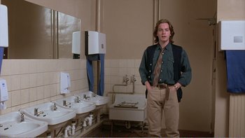 Movie still from “Shallow Grave” (1994), directed by Danny Boyle – A man standing in front of a bathroom sink; Medium shot, Low angle