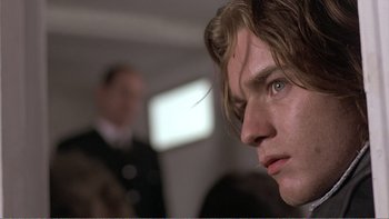 Movie still from “Shallow Grave” (1994), directed by Danny Boyle – A man's face in front of another man in the background; Close Up shot, Over the shoulder angle