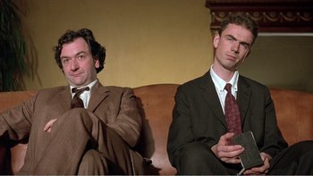 Movie still from “Shallow Grave” (1994), directed by Danny Boyle – A couple of men sitting next to each other on top of a couch; Close Up shot, Low angle