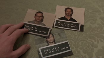 Movie still from “Shallow Grave” (1994), directed by Danny Boyle – A person is holding up a picture of a man; Close Up shot, Overhead angle