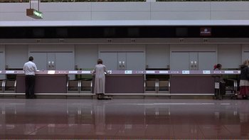 Movie still from “Shallow Grave” (1994), directed by Danny Boyle – A person standing in front of a row of counters; Extreme Wide shot, High angle