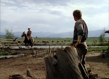Movie still from “Shane” (1953), directed by George Stevens – Two men on horseback in an open field; Wide shot, Over the shoulder angle