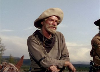Movie still from “Shane” (1953), directed by George Stevens – A man with a beard and a hat on a horse; Medium shot, Low angle