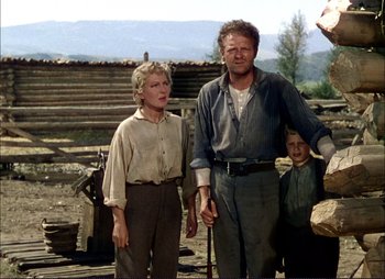 Movie still from “Shane” (1953), directed by George Stevens – An older man and a younger woman standing next to a young boy; Medium shot, Low angle