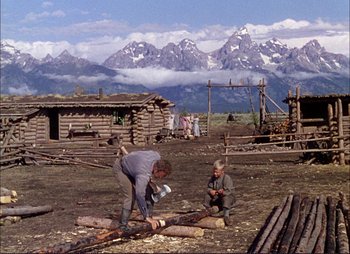 Movie still from “Shane” (1953), directed by George Stevens – Two men working in a field with mountains in the background; Wide shot, Over the shoulder angle