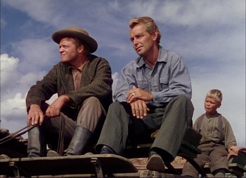 Movie still from “Shane” (1953), directed by George Stevens – A group of men sitting next to each other on top of a train; Medium shot, Low angle
