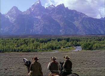 Movie still from “Shane” (1953), directed by George Stevens – A group of people riding horses in a field; Extreme Wide shot, Low angle