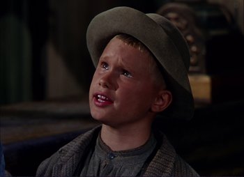 Movie still from “Shane” (1953), directed by George Stevens – A young boy wearing a brown hat and a brown jacket; Close Up shot, Low angle