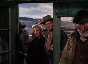 Movie still from “Shane” (1953), directed by George Stevens – A group of people standing in front of an open door; Medium shot, Low angle