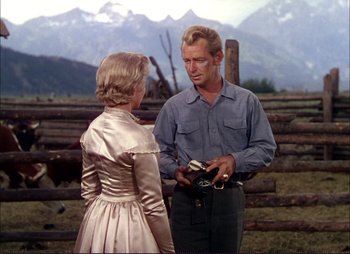 Movie still from “Shane” (1953), directed by George Stevens – A man and a woman standing next to each other in front of mountains; Medium shot, Over the shoulder angle