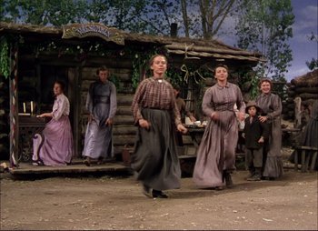 Movie still from “Shane” (1953), directed by George Stevens – A group of people dressed in period clothing dancing; Wide shot, Low angle