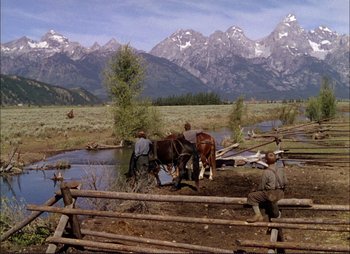 Movie still from “Shane” (1953), directed by George Stevens – Two men on horses drink water from a stream; Wide shot, Over the shoulder angle