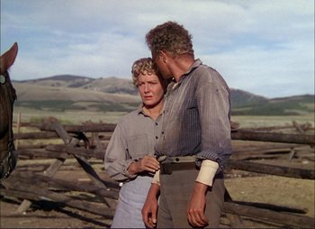 Movie still from “Shane” (1953), directed by George Stevens – A man and a woman standing next to each other in a field; Medium shot, Over the shoulder angle