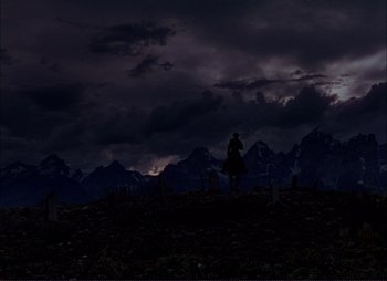 Movie still from “Shane” (1953), directed by George Stevens – A person riding a horse in a field at night; Extreme Wide shot, Low angle