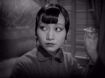 Movie still from “Shanghai Express” (1932), directed by Josef von Sternberg – An asian woman with a cigarette in her mouth; Close Up shot, Over the shoulder angle