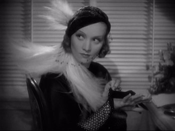 Movie still from “Shanghai Express” (1932), directed by Josef von Sternberg – A black - and - white photo of a woman with a feather in her hair; Close Up shot, Over the shoulder angle