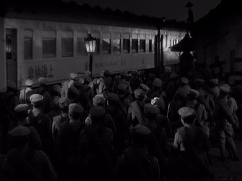 Movie still from “Shanghai Express” (1932), directed by Josef von Sternberg – Black and white photograph of a crowd of people next to a train; Extreme Wide shot, High angle