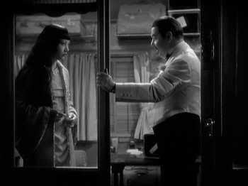 Movie still from “Shanghai Express” (1932), directed by Josef von Sternberg – A man and a woman standing next to each other in front of a mirror; Medium shot, High angle