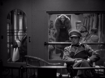 Movie still from “Shanghai Express” (1932), directed by Josef von Sternberg – A man in uniform sitting in front of a train window; Wide shot, Over the shoulder angle