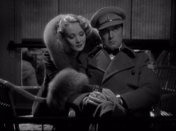 Movie still from “Shanghai Express” (1932), directed by Josef von Sternberg – A man and a woman sitting next to each other; Medium shot, Low angle