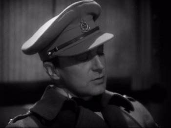 Movie still from “Shanghai Express” (1932), directed by Josef von Sternberg – A man wearing a uniform and a hat; Close Up shot, High angle