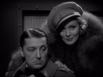 Movie still from “Shanghai Express” (1932), directed by Josef von Sternberg – A man and a woman posing for a picture in an army uniform; Close Up shot, Low angle