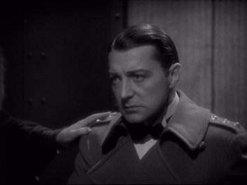 Movie still from “Shanghai Express” (1932), directed by Josef von Sternberg – A black - and - white photo of a man in a military uniform; Close Up shot, Over the shoulder angle