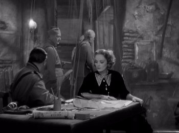 Movie still from “Shanghai Express” (1932), directed by Josef von Sternberg – A woman sitting at a table in front of two men; Medium shot, High angle