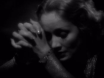 Movie still from “Shanghai Express” (1932), directed by Josef von Sternberg – A black and white photo of a woman with her hands clasped together; Close Up shot, High angle