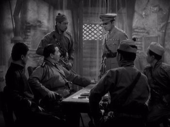 Movie still from “Shanghai Express” (1932), directed by Josef von Sternberg – A group of men standing next to each other in front of a table; Medium shot, Over the shoulder angle