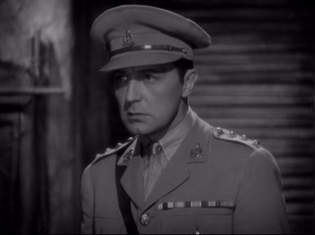 Movie still from “Shanghai Express” (1932), directed by Josef von Sternberg – A man in a military uniform is standing in front of a building; Close Up shot, High angle