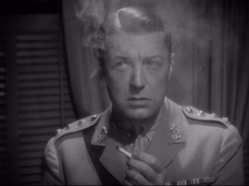 Movie still from “Shanghai Express” (1932), directed by Josef von Sternberg – A man smoking a cigarette while wearing a military uniform; Close Up shot, Low angle