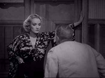 Movie still from “Shanghai Express” (1932), directed by Josef von Sternberg – A black and white photo of a woman and a man in front of a mirror; Medium shot, Over the shoulder angle