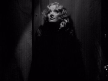 Movie still from “Shanghai Express” (1932), directed by Josef von Sternberg – A black and white photo of a woman in a dark room; Close Up shot, Low angle