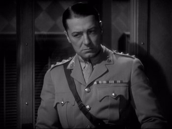 Movie still from “Shanghai Express” (1932), directed by Josef von Sternberg – A man in a military uniform is standing in front of a building; Close Up shot, Low angle