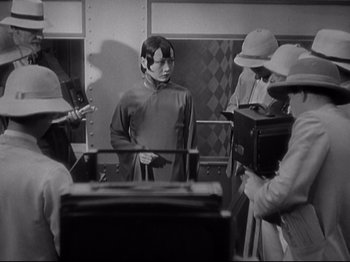 Movie still from “Shanghai Express” (1932), directed by Josef von Sternberg – A group of people standing in a room; Medium shot, Over the shoulder angle