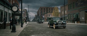 Movie still from “1922” (2017), directed by Zak Hilditch – An old car is driving down the street; Extreme Wide shot, High angle