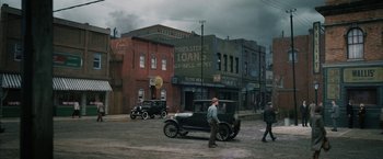 Movie still from “1922” (2017), directed by Zak Hilditch – An old car is parked on the side of the street; Extreme Wide shot, High angle