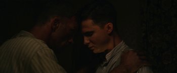 Movie still from “1922” (2017), directed by Zak Hilditch – A man and a boy are touching heads in the dark; Close Up shot, Over the shoulder angle