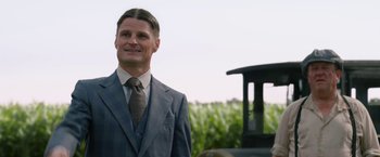 Movie still from “1922” (2017), directed by Zak Hilditch – A man in a suit and tie standing next to a fire hydrant; Close Up shot, Over the shoulder angle
