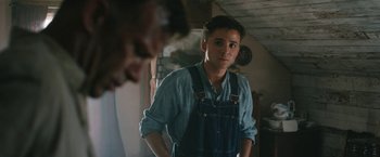 Movie still from “1922” (2017), directed by Zak Hilditch – A young man wearing a blue shirt and blue overalls; Close Up shot, Over the shoulder angle