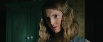 Movie still from “1922” (2017), directed by Zak Hilditch – A young girl with long blonde hair stares at the camera; Close Up shot, Over the shoulder angle