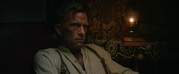 Movie still from “1922” (2017), directed by Zak Hilditch – A person sitting on a couch; Close Up shot, Low angle